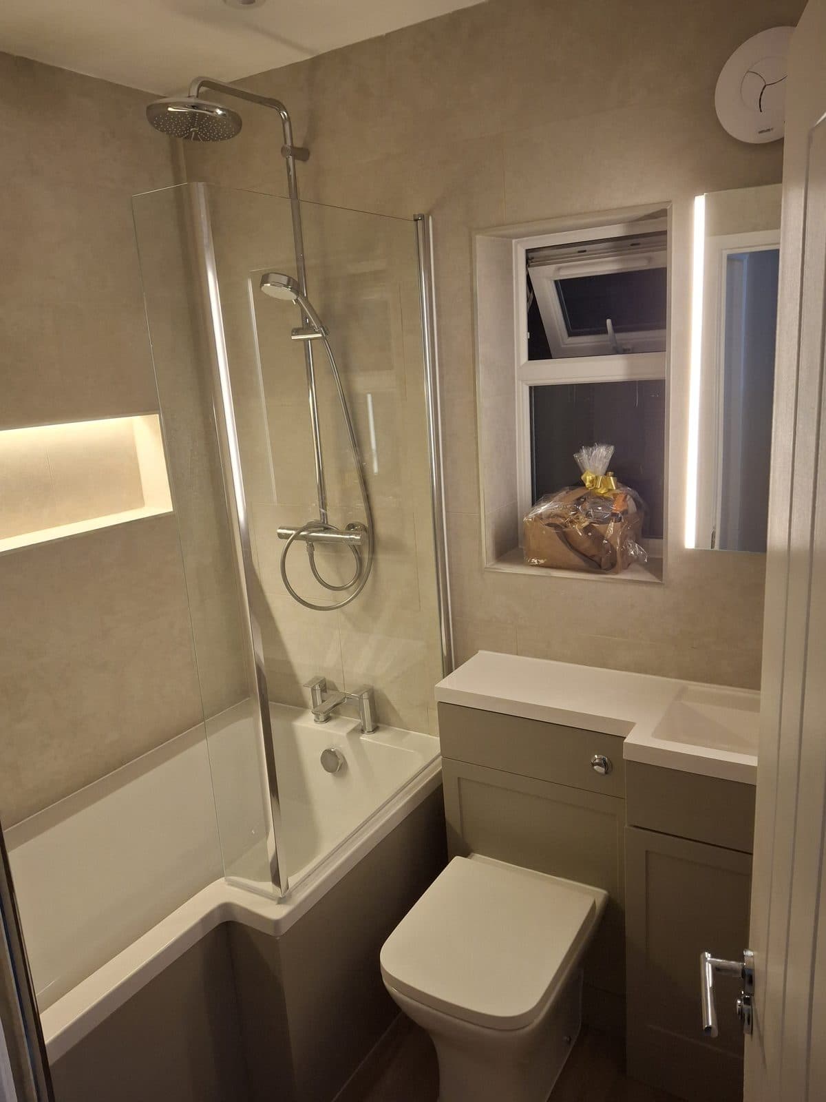 L-shaped shower bath and grey vanity unit fitted by HOC Home Improvements in Surrey