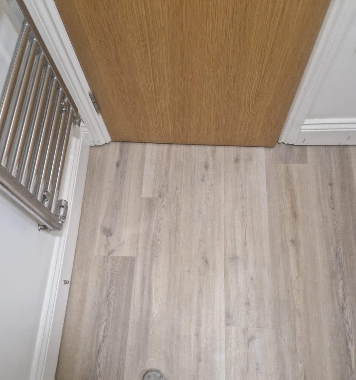 Wood-effect bathroom flooring fitted by HOC Home Improvements in Surrey